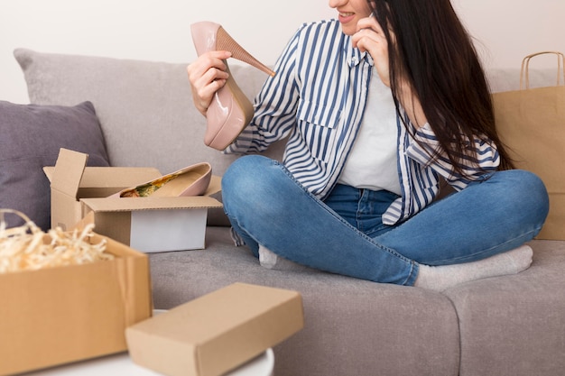 Kostenloses Foto frau, die ihre neuen schuhe beim sitzen auf sofa überprüft