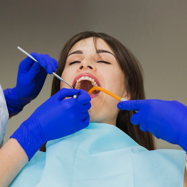 Frau, die ihre Zähne von den Zahnärzten überprüfen lässt
