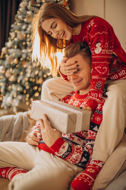 Frau, die ihrem Freund ein Weihnachtsgeschenk macht