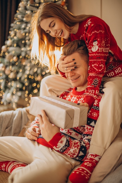 Frau, die ihrem Freund ein Weihnachtsgeschenk macht