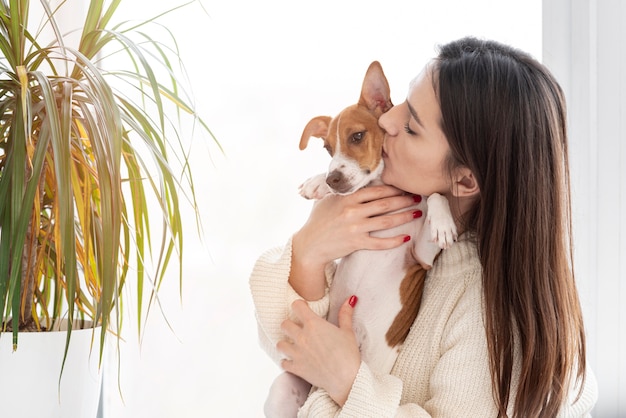 Frau, die ihrem niedlichen Hund einen Kuss gibt