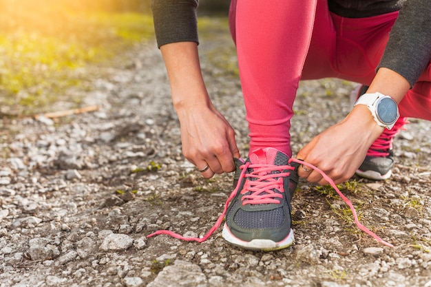 Frau, die ihren grauen Turnschuh bindet