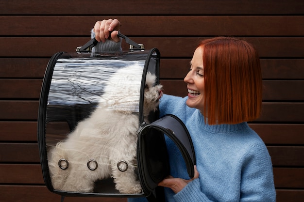 Frau, die ihren Hund in einer speziellen Tragetasche trägt