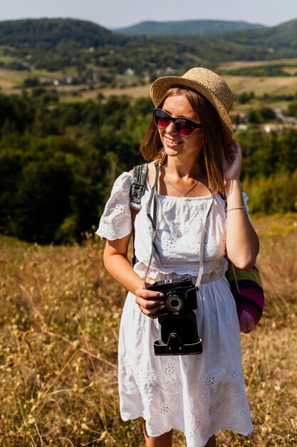 Kostenloses Foto frau, die ihren hut hält und weg schaut