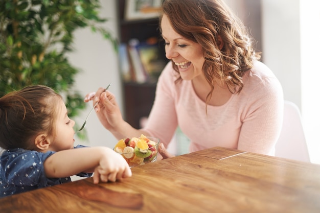 Frau, die ihrer Tochter Obst gibt