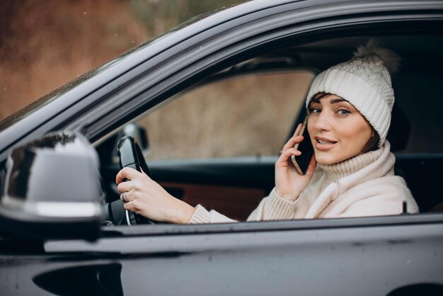 Frau, die im Auto fährt und Telefon benutzt