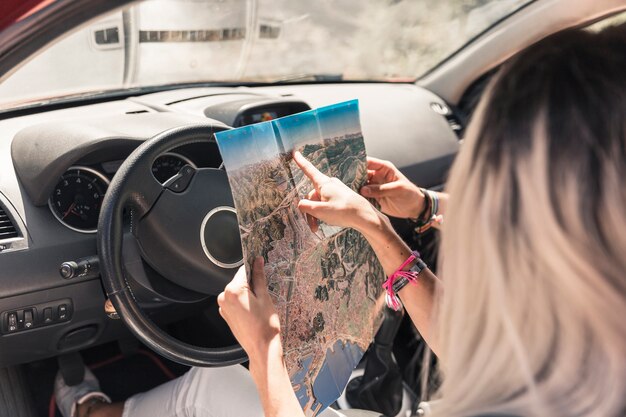 Frau, die im Auto zeigt Karte zu ihrem Freund sitzt