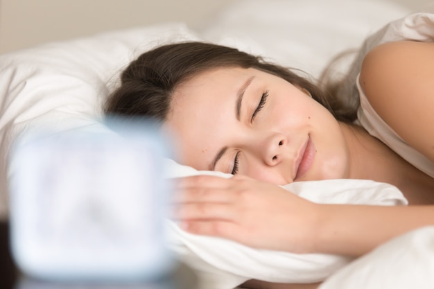 Frau, die im Bett sich entspannt, bevor sie bei der Arbeit geht