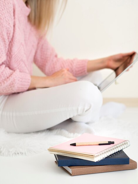 Frau, die im Bett sitzt und digitales Tablett verwendet