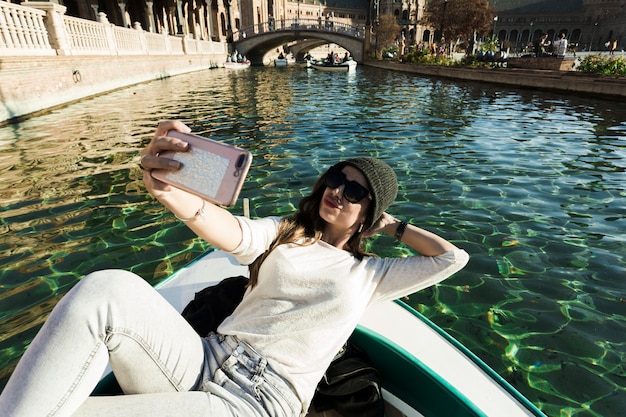 Kostenloses Foto frau, die im boot liegt und selfie nimmt