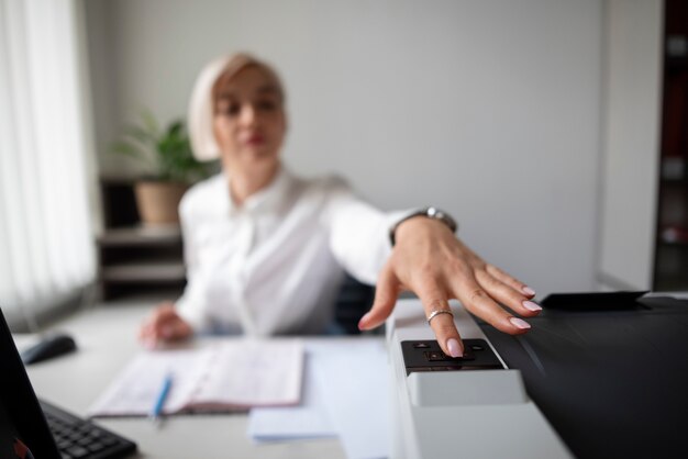 Frau, die im Büro arbeitet und einen Drucker benutzt
