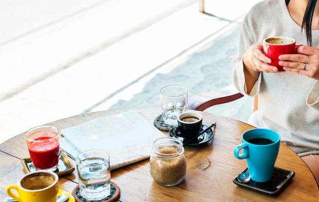 Frau, die im Kaffeecafé mit Karte auf Holztisch sitzt