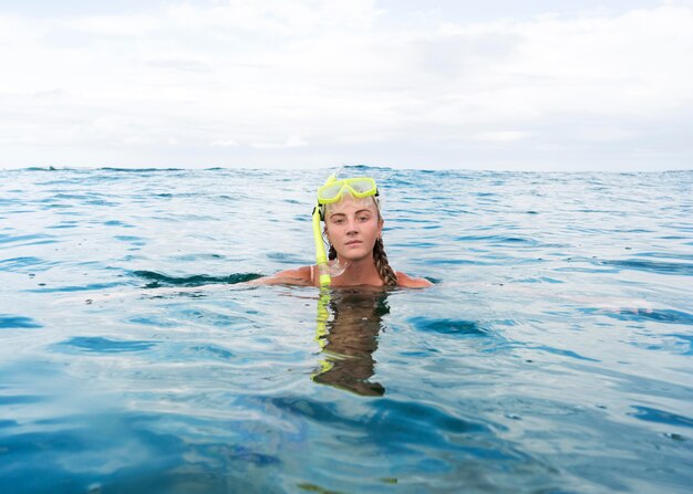 Frau, die im Ozean mit Tauchausrüstung schwimmt