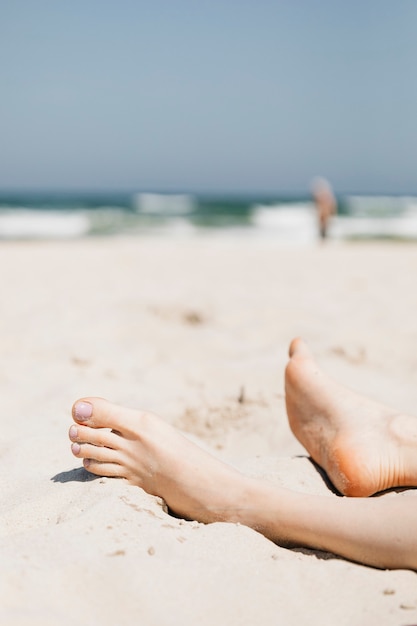 Frau, die im Sand an einem Strand entspannt