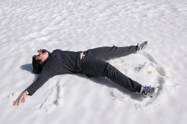 Frau, die im Schnee liegt