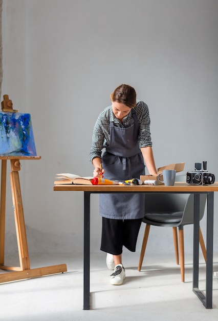 Frau, die im Studio mit Malerei arbeitet