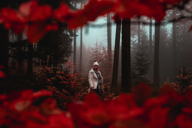 Frau, die im Wald während des Herbstes aufwirft