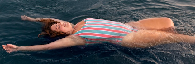 Kostenloses Foto frau, die im wasser am strand entspannt