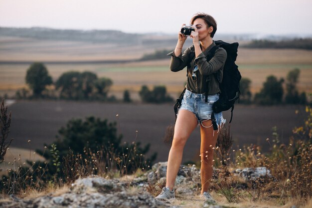 Frau, die in den Bergen wandert und Foto macht