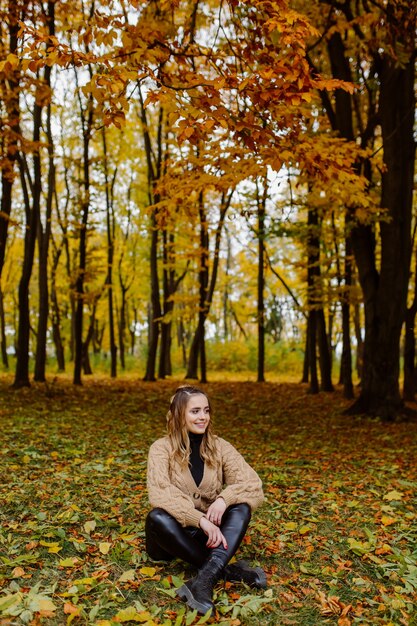 Frau, die in den Herbstpark geht