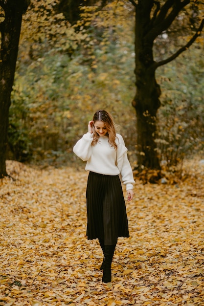 Frau, die in den Herbstpark geht