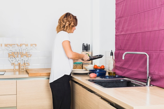 Frau, die in der gemütlichen Küche kocht