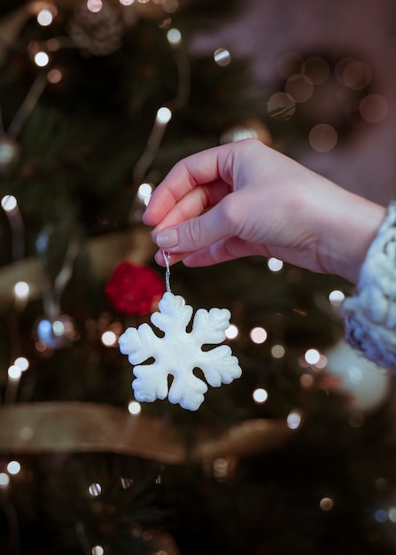 Frau, die in der Hand kleine Schneeflocke hält