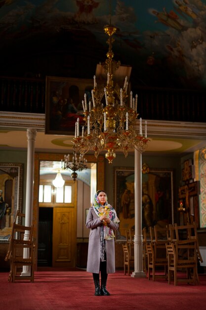 Frau, die in der Kirche für religiöse Wallfahrt betet