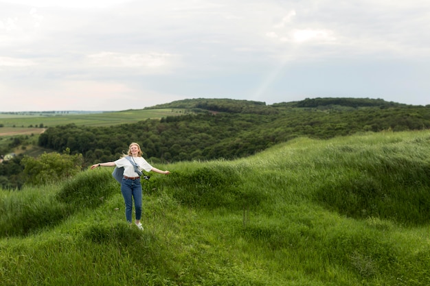 Frau, die in der Natur mit Bergen aufwirft