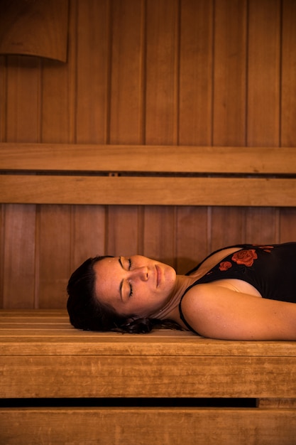 Frau, die in der Sauna sich entspannt