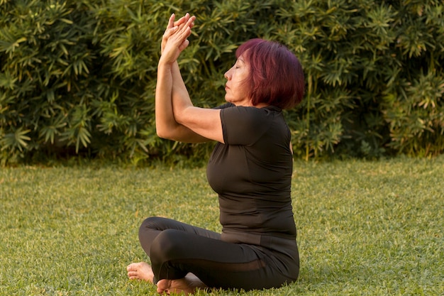 Frau, die in der Yoga-Position sitzt und Armübungen macht