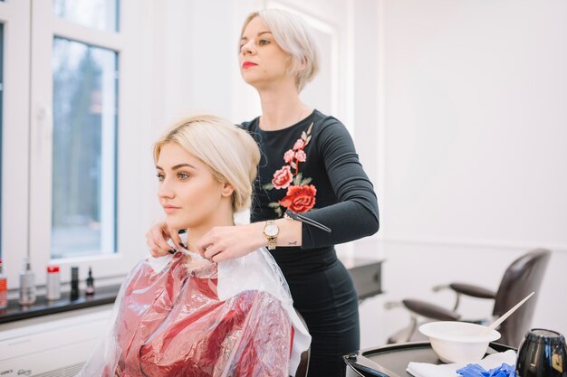 Frau, die junges Mädchen für Haarbehandlung vorbereitet