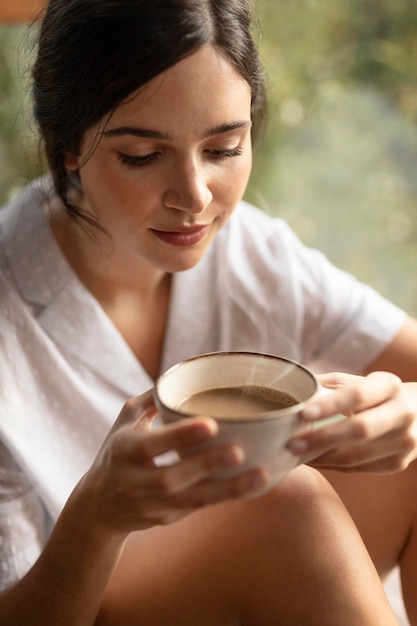 Frau, die Kaffeetasse hält