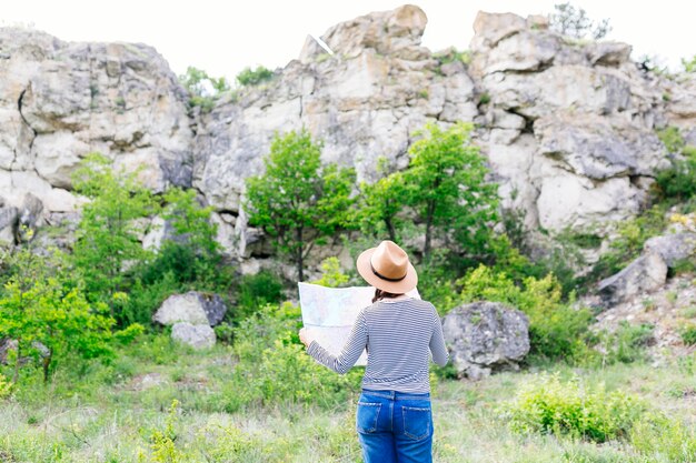 Frau, die Karte in der Natur betrachtet