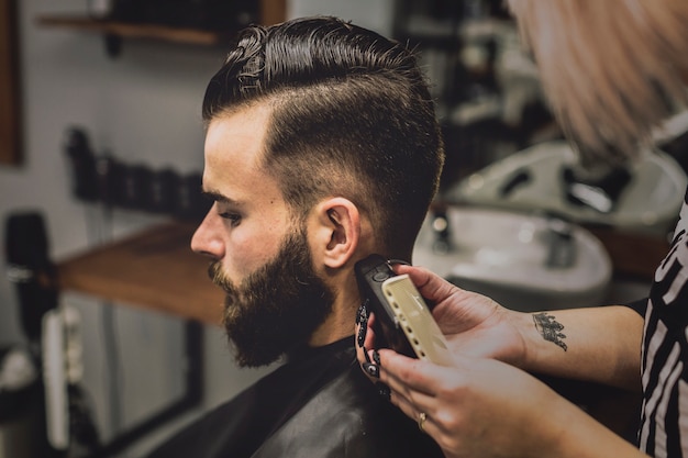 Kostenloses Foto frau, die kunden im friseursalon pflegt