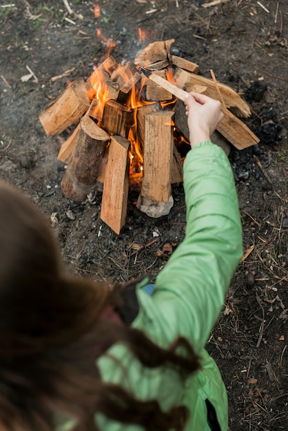 Kostenloses Foto frau, die lagerfeuer macht