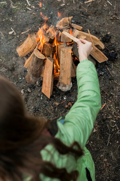 Frau, die Lagerfeuer macht