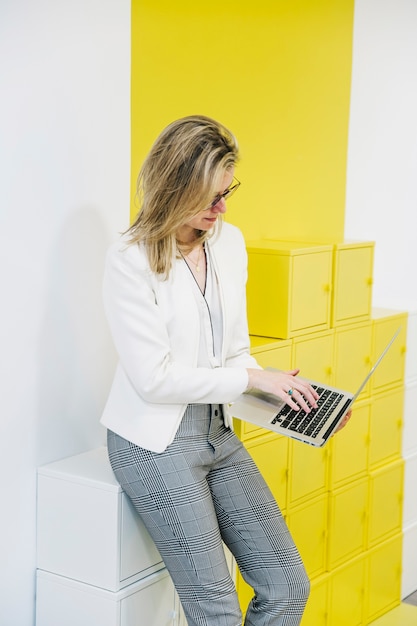 Kostenloses Foto frau, die laptop auf buntem hintergrund durchstöbert