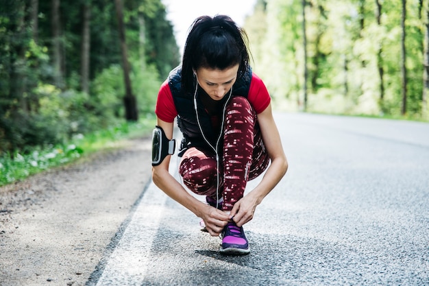 Kostenloses Foto frau, die laufschuhe auf straße bindet