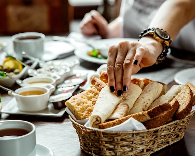 Frau, die Lavash vom Brotkorb nimmt