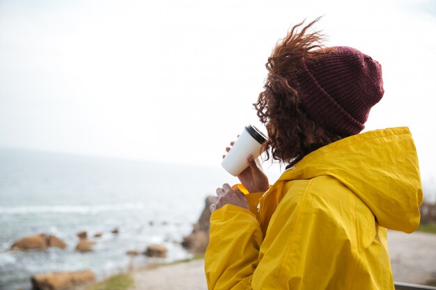 Frau, die Meer im Herbst betrachtet