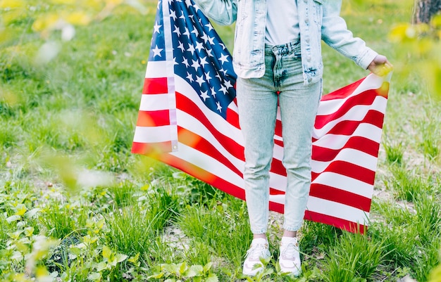 Frau, die mit amerikanischer Flagge steht