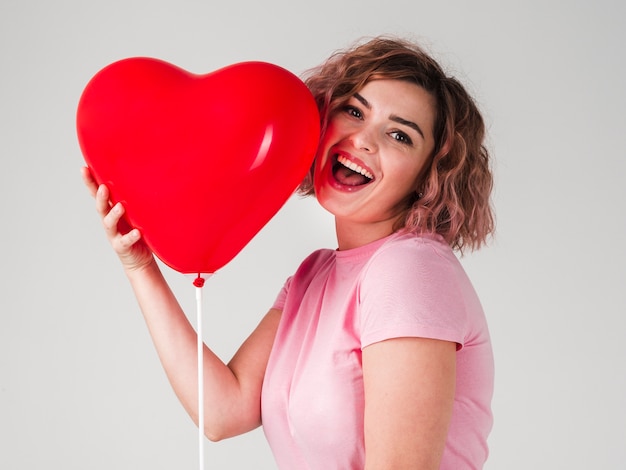 Frau, die mit Ballon lächelt und aufwirft