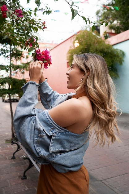 Kostenloses Foto frau, die mit blumenseitenansicht aufwirft