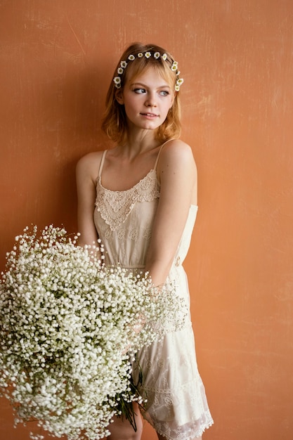 Kostenloses Foto frau, die mit blumenstrauß der herrlichen blumen aufwirft