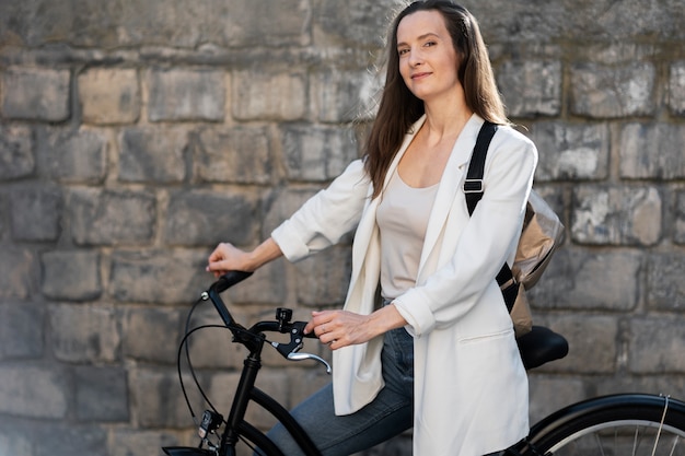 Kostenloses Foto frau, die mit dem fahrrad zur arbeit geht