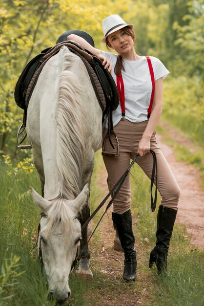 Kostenloses Foto frau, die mit einem pferd in der landschaft geht