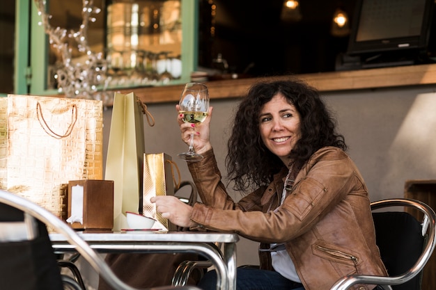 Kostenloses Foto frau, die mit einkaufstaschen und wein sitzt