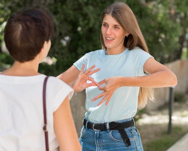 Frau, die mit Freund unter Verwendung der Gebärdensprache spricht