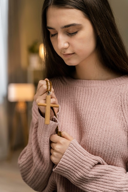 Frau, die mit Holzkreuz betet